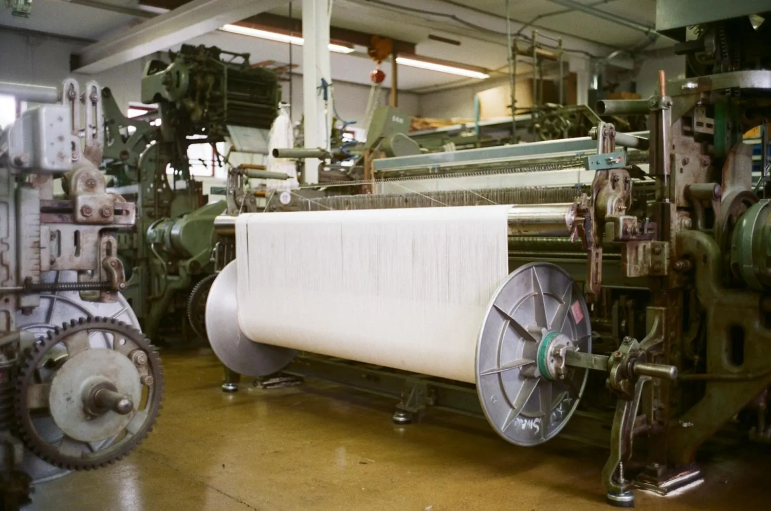 Tear industrial a produzir um tecido branco, em preto e branco